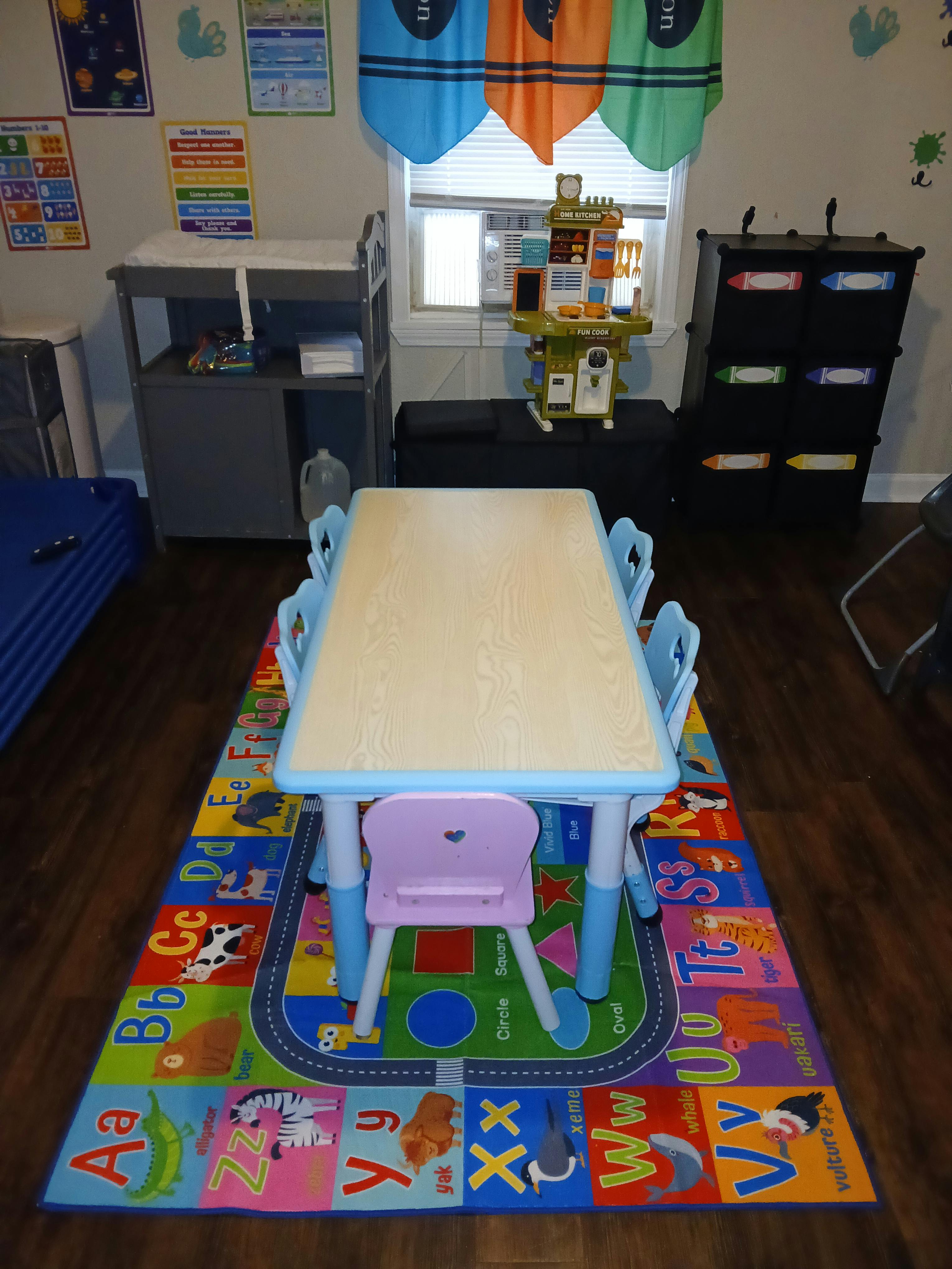 Children's table and chairs on an alphabet rug in a classroom