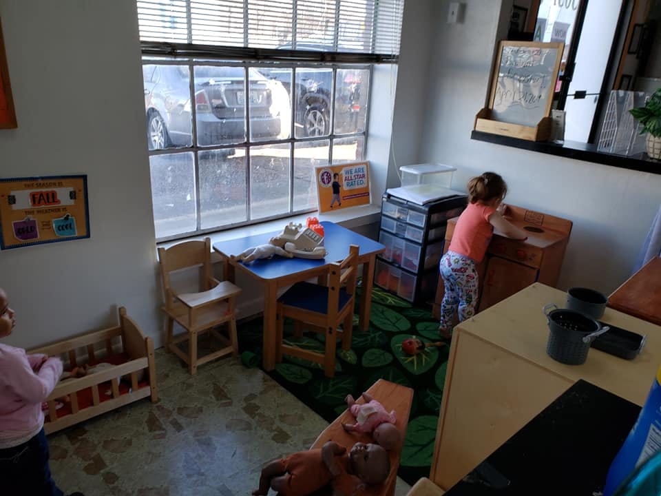 Child playing in a room with a small table and chairs