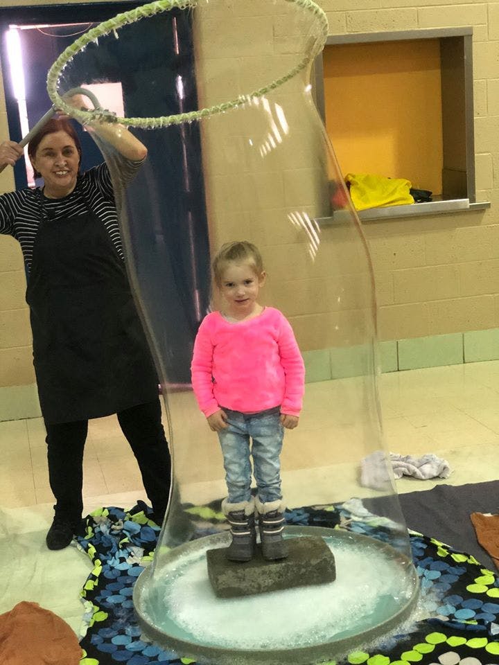 Person making a large bubble around a child