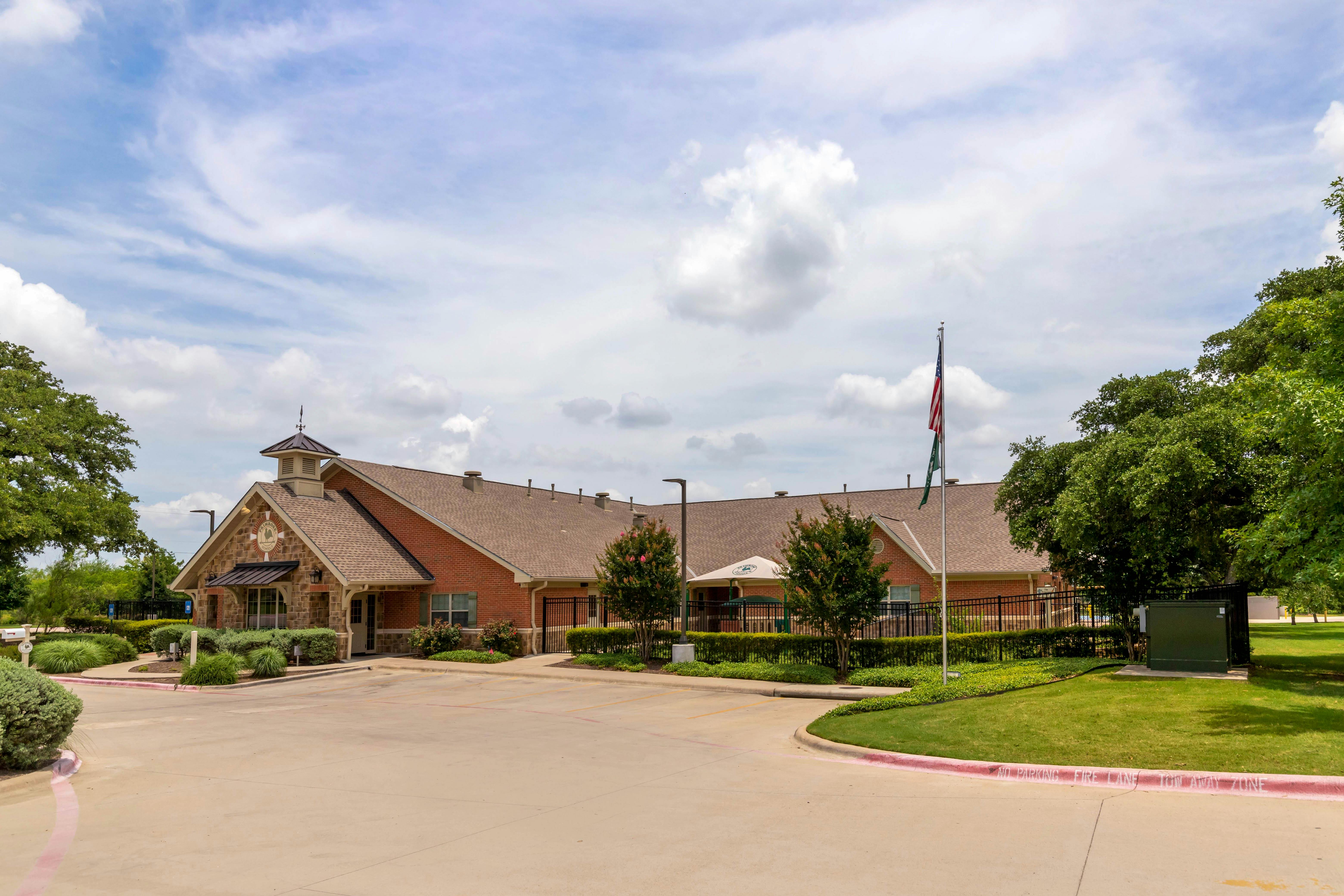 Brick building with a stone facade, cupola, and an American flag flying outside