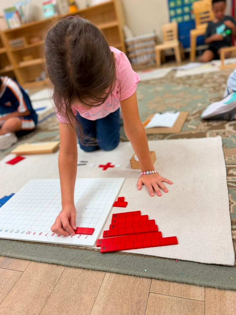 Child working with math blocks on a grid in a classroom