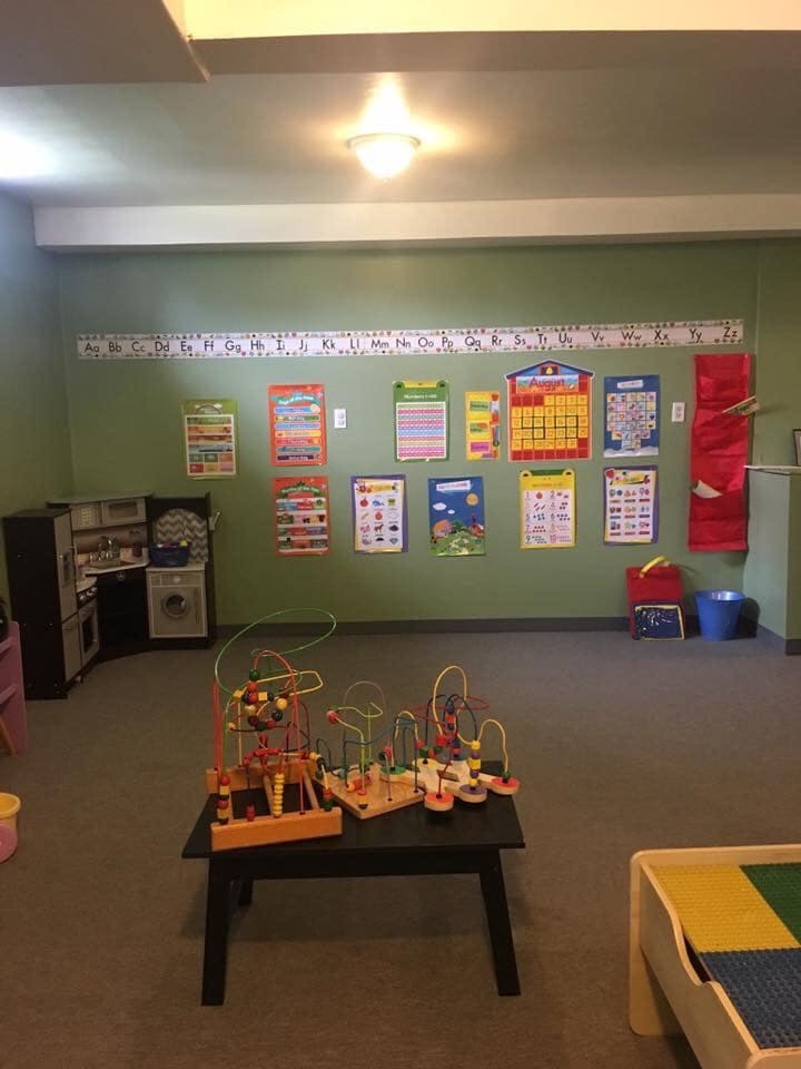 Playroom with educational posters on the wall and toys on a table