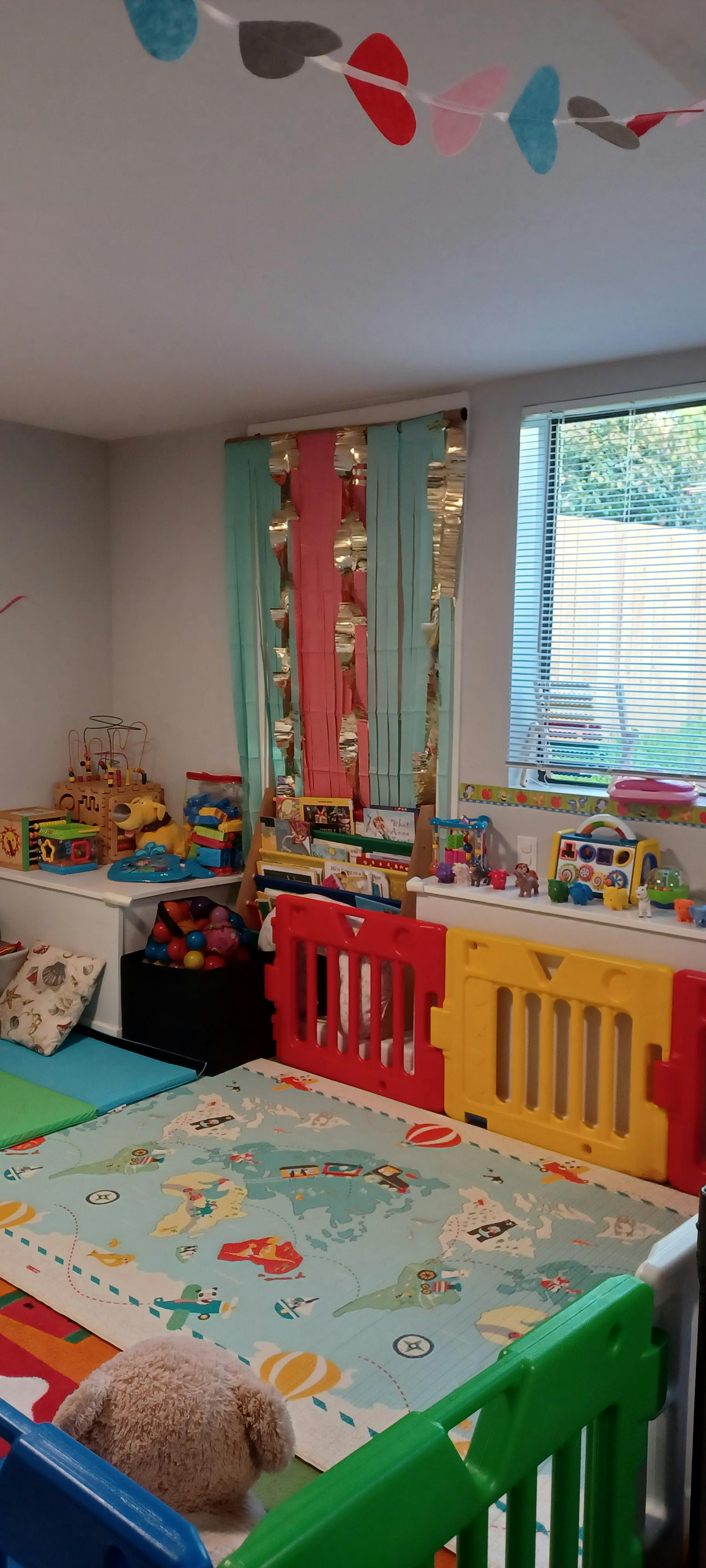 Playroom with colorful play mats, toys, and safety gates