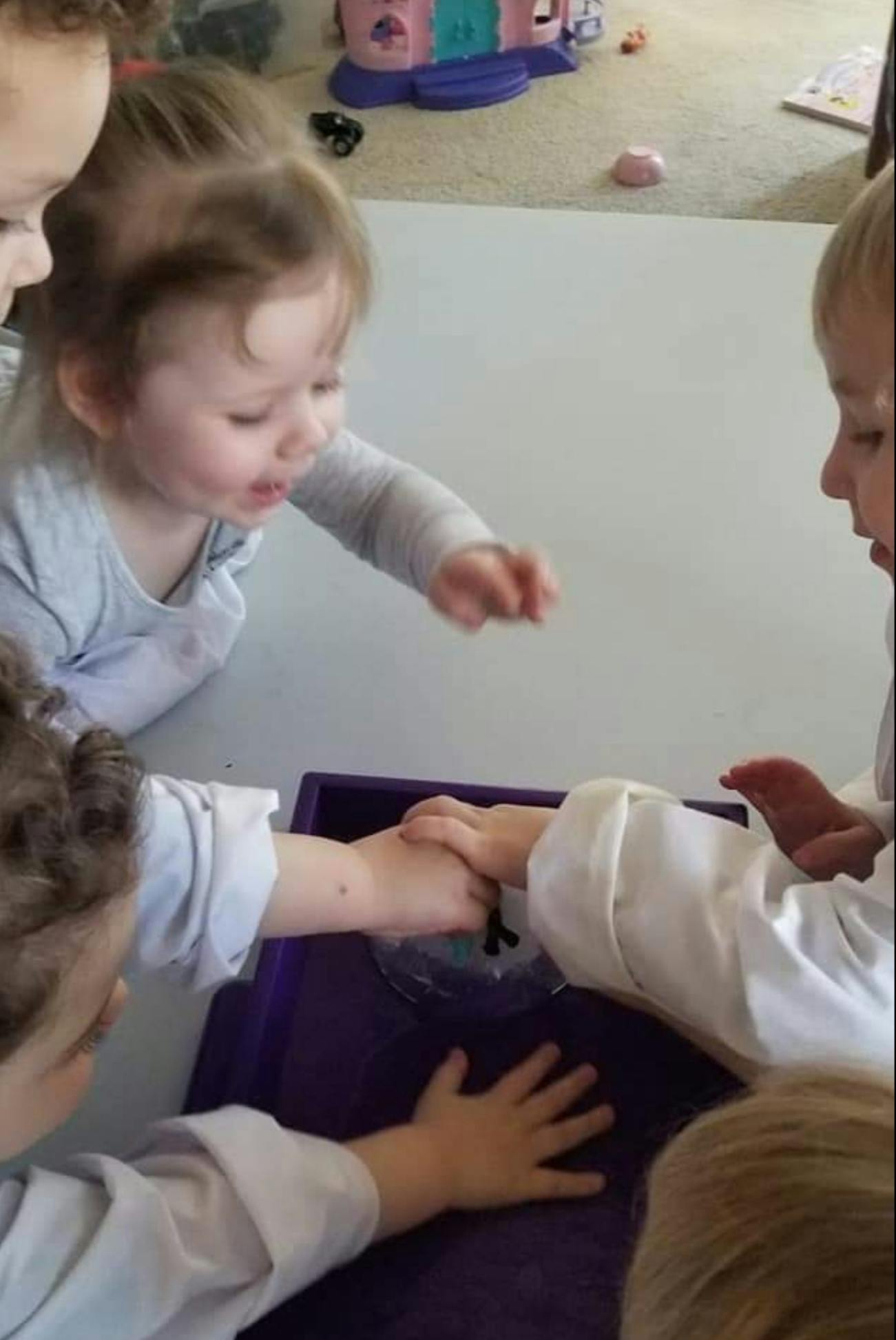 Children playing with a purple tray