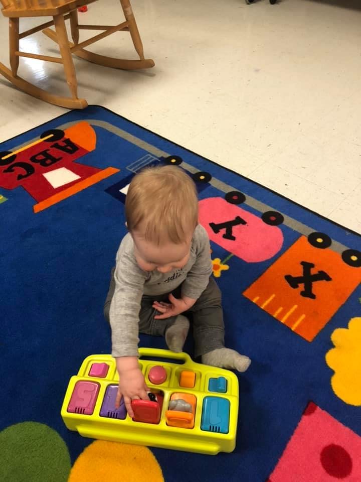 Child playing with a toy on a rug
