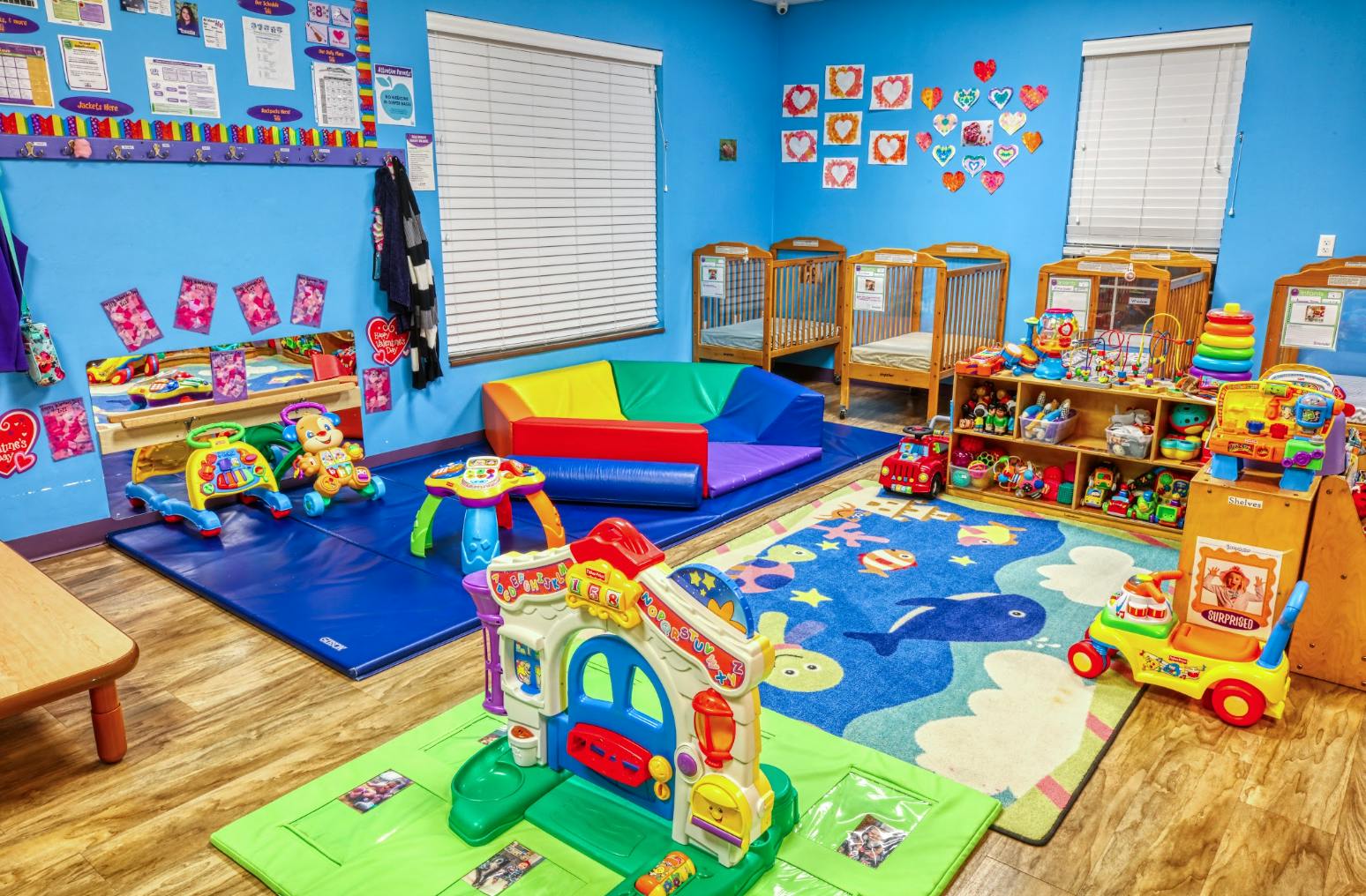 Baby and toddler toys and cribs in a daycare room