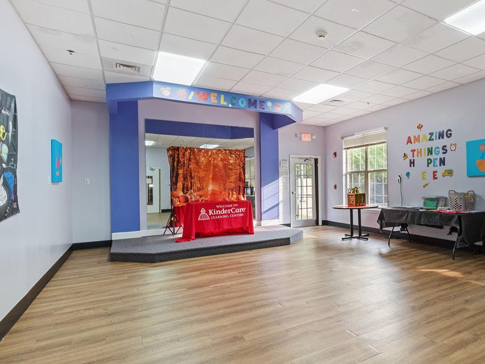 Empty room with a small stage and "WELCOME" sign above an archway