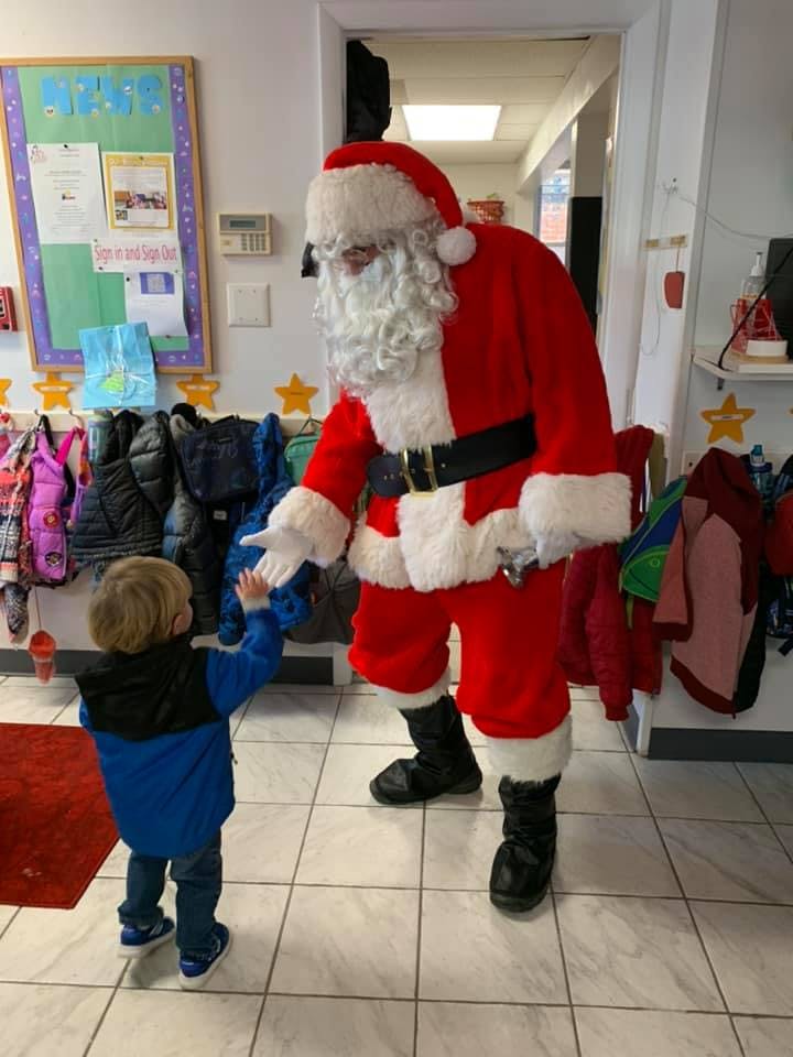 Person in Santa costume reaching out to a child