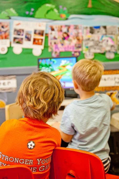Two children watching a screen