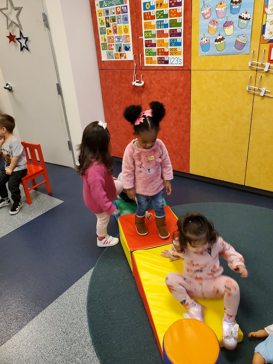 Children playing on soft play equipment in a classroom
