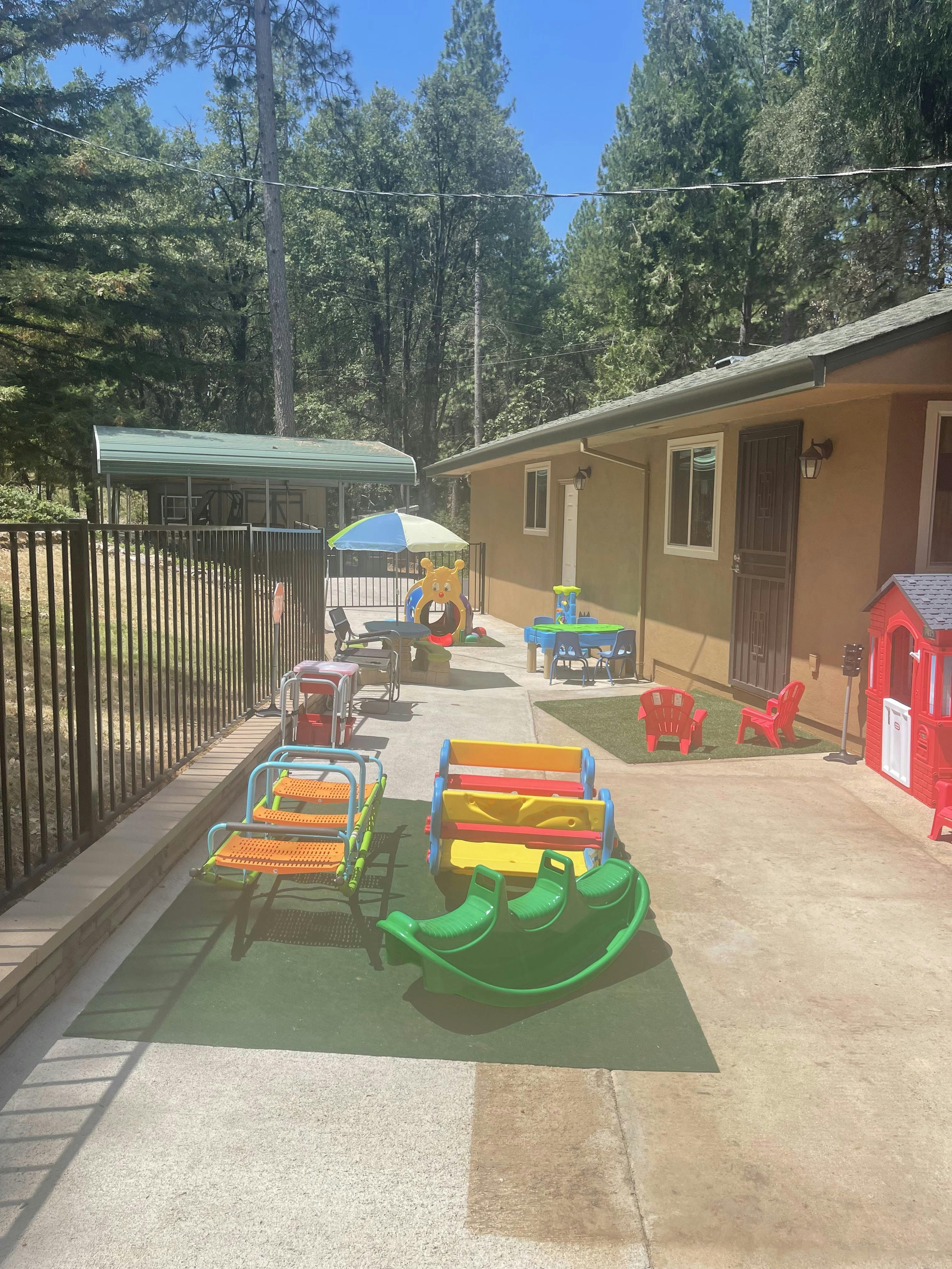 Outdoor play area with various colorful toys and a small building