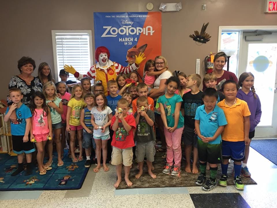 Adults and children posing with a person dressed as a clown