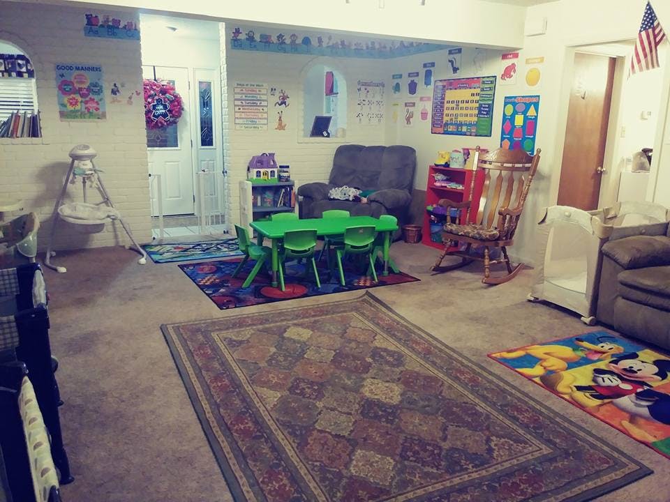Playroom with small green table and chairs, adult furniture, and rugs