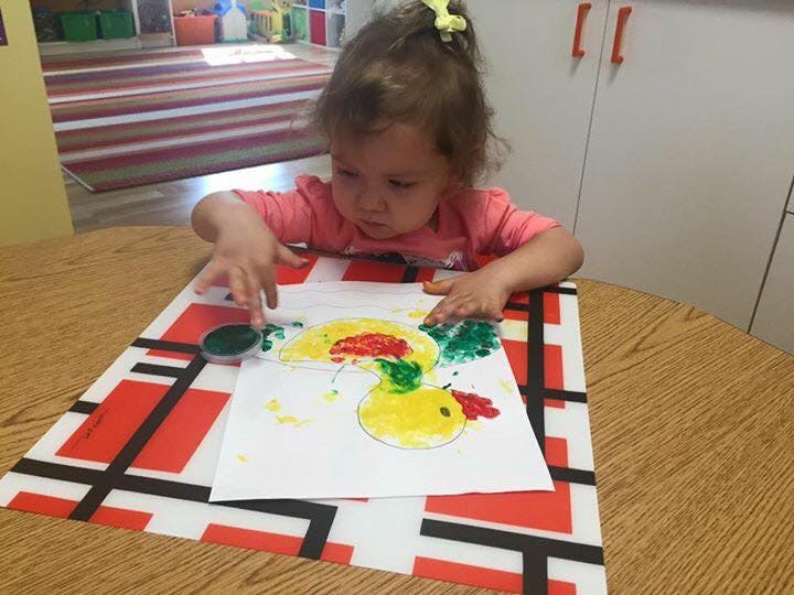 Child finger painting on paper atable