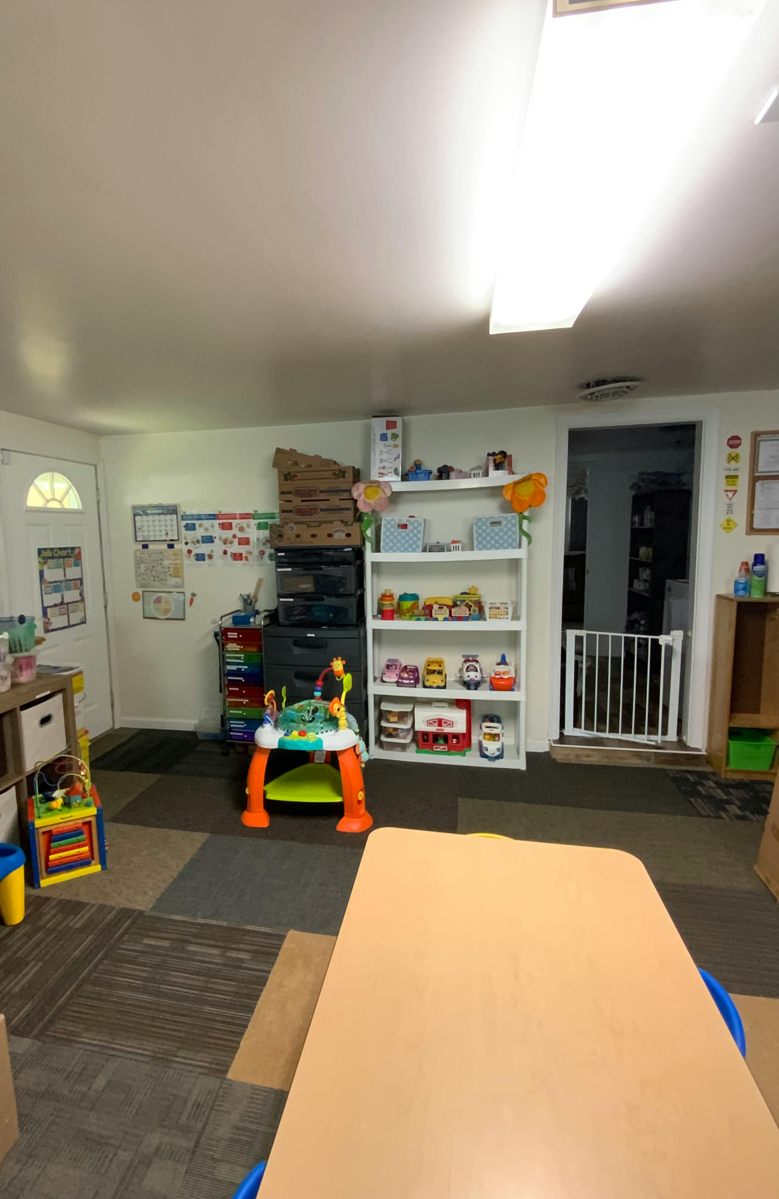 Playroom with toys, shelves, and a child safety gate