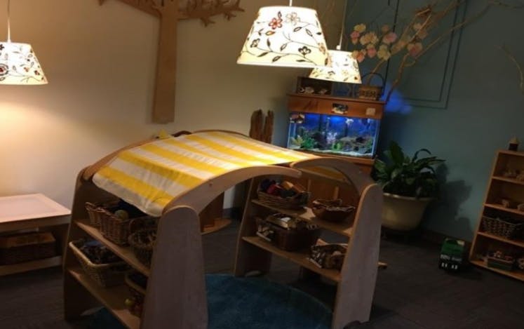 Play structure with yellow and white striped fabric, shelves, and a fish tank