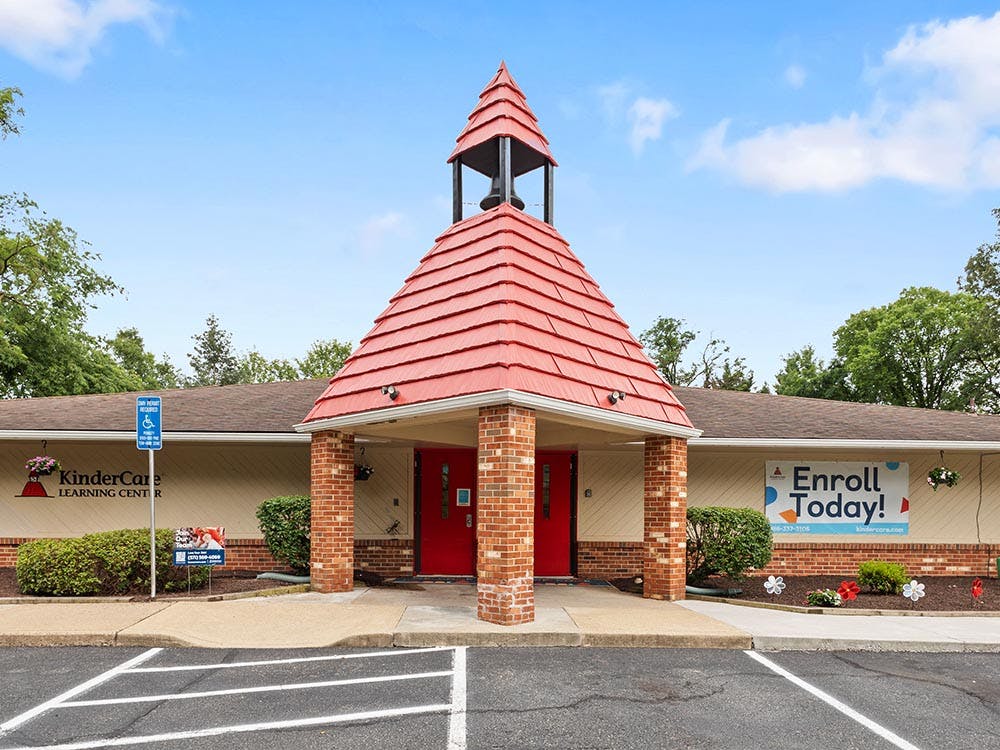 KinderCare Learning Center building with red doors and bell tower