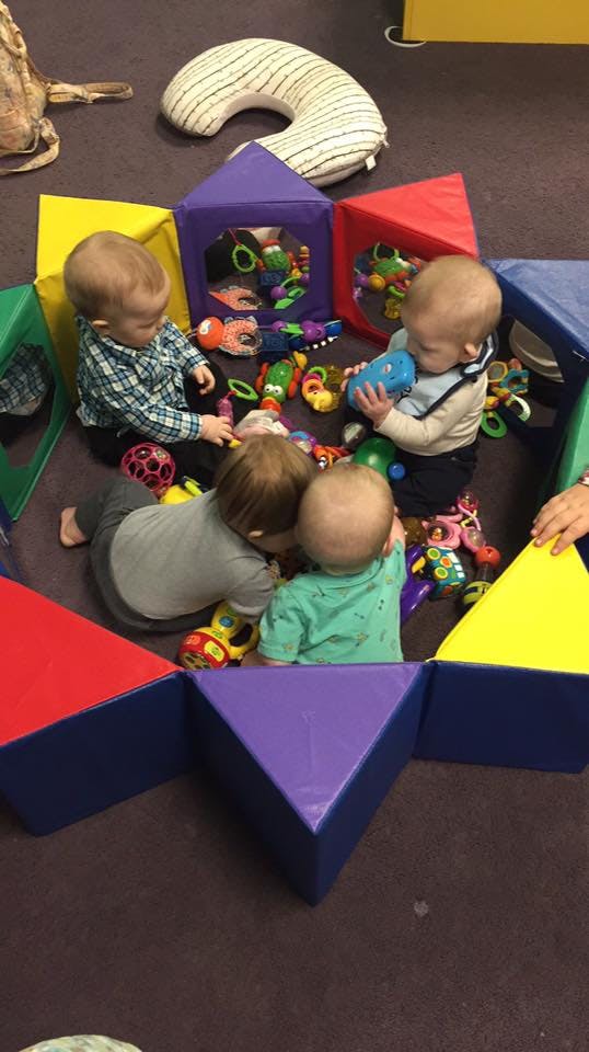 Multiple children playing with toys on the floor