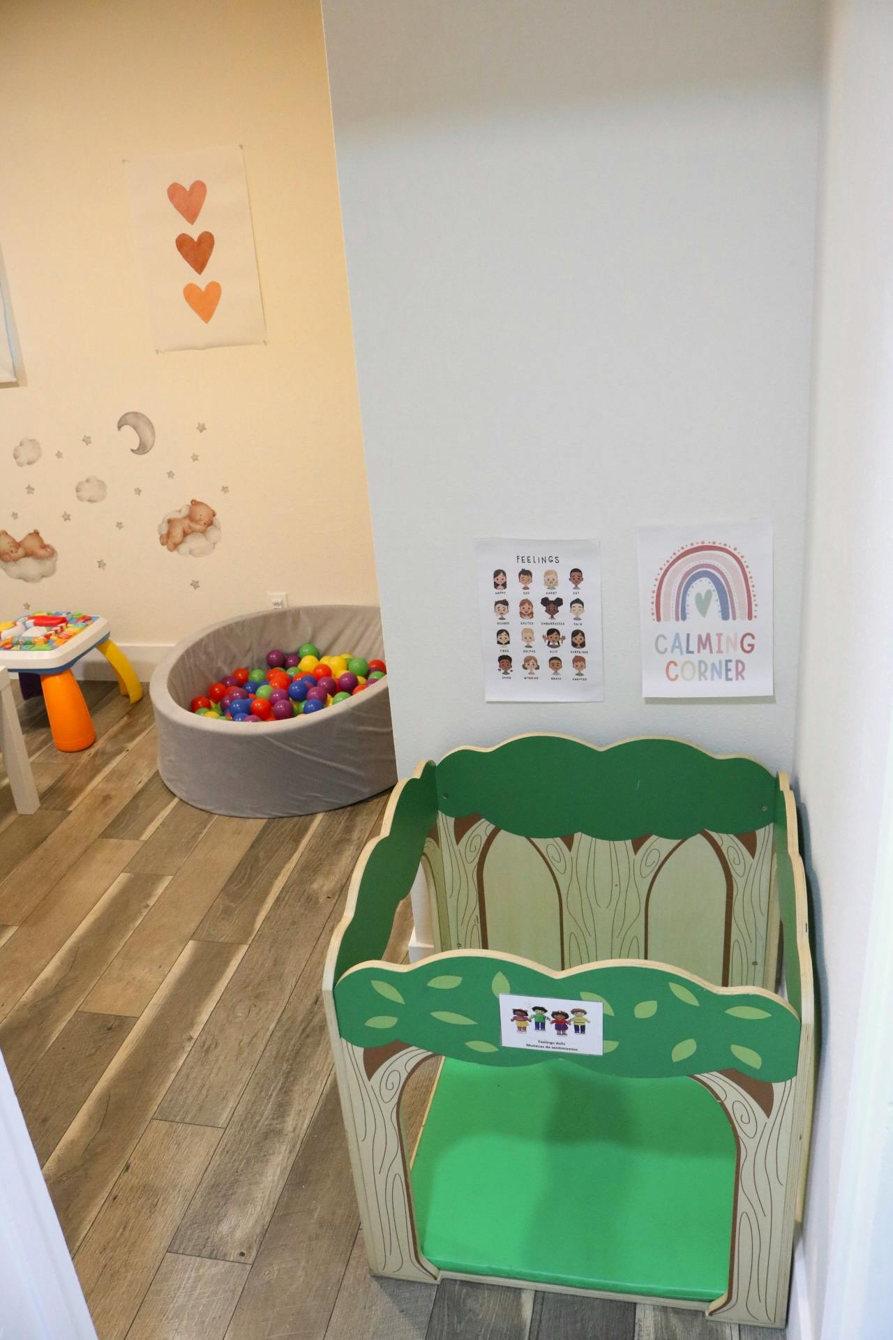 Playroom with a ball pit, small table, and a tree-shaped play structure