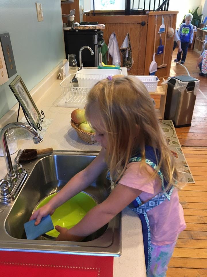 Child washing a dish in a sink
