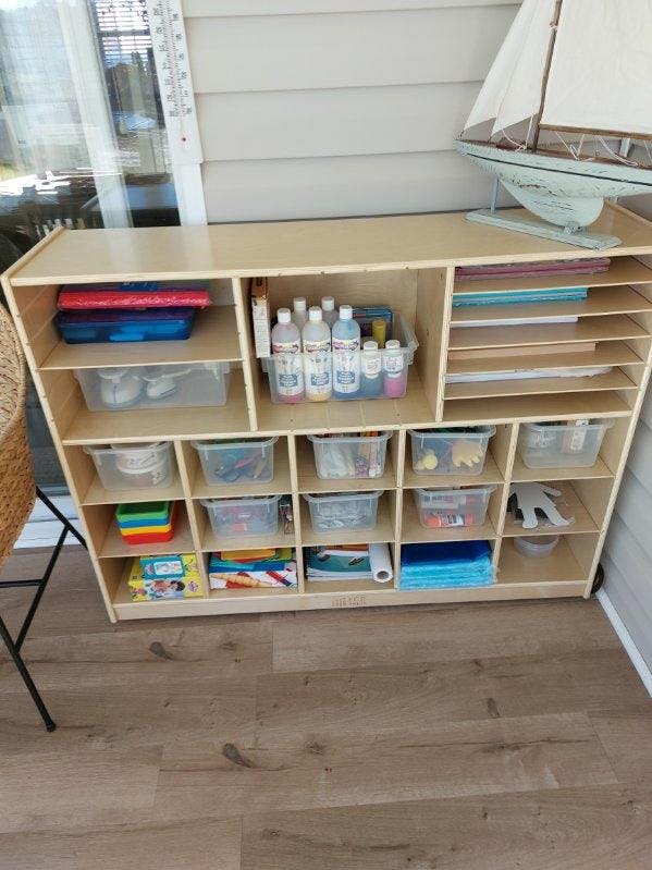 Wooden storage unit with various art supplies and containers
