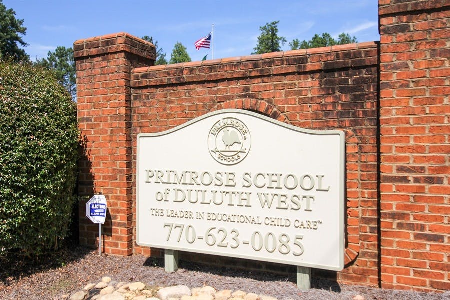Primrose School of Duluth West sign in front of a brick wall
