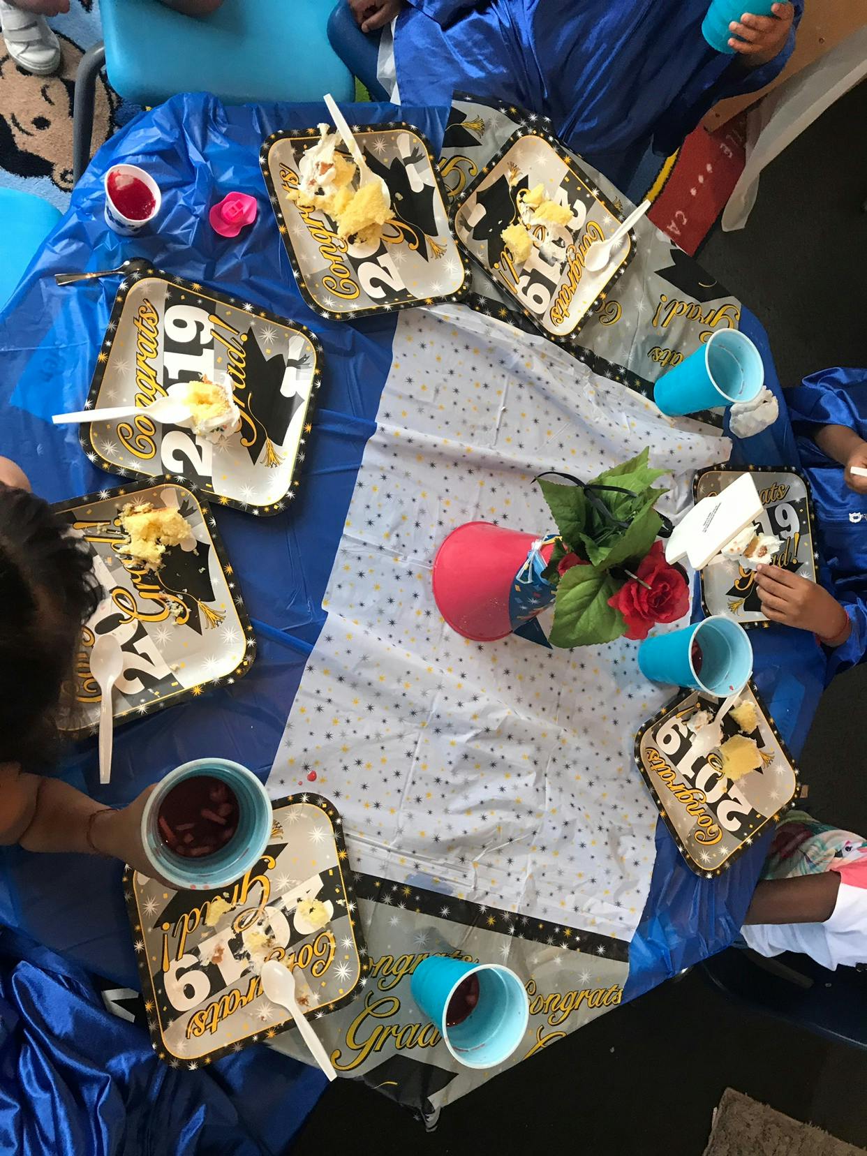 Table set with graduation-themed plates, cups, and dessert