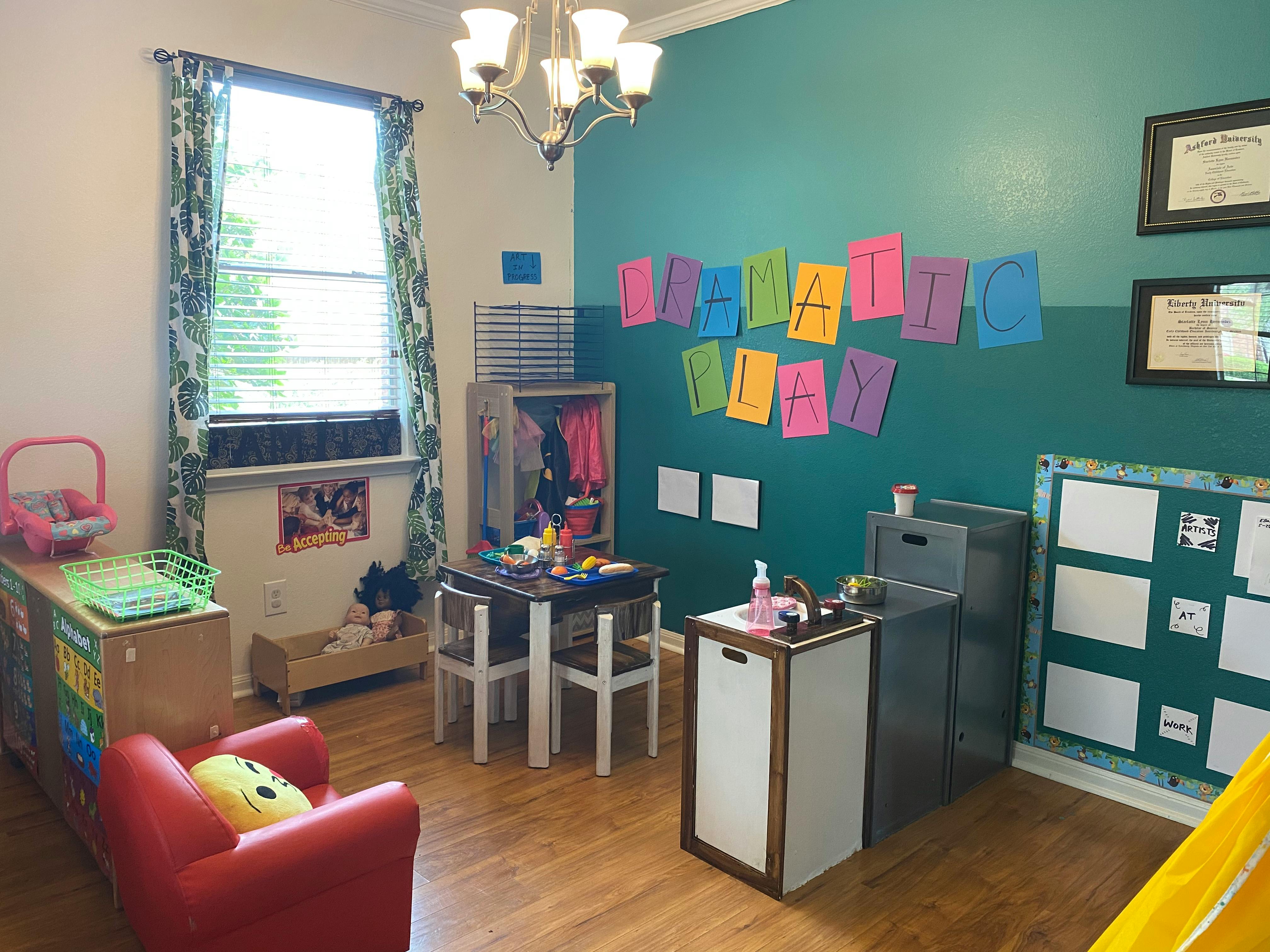 Children's play area with small tables, chairs, and colorful wall decorations