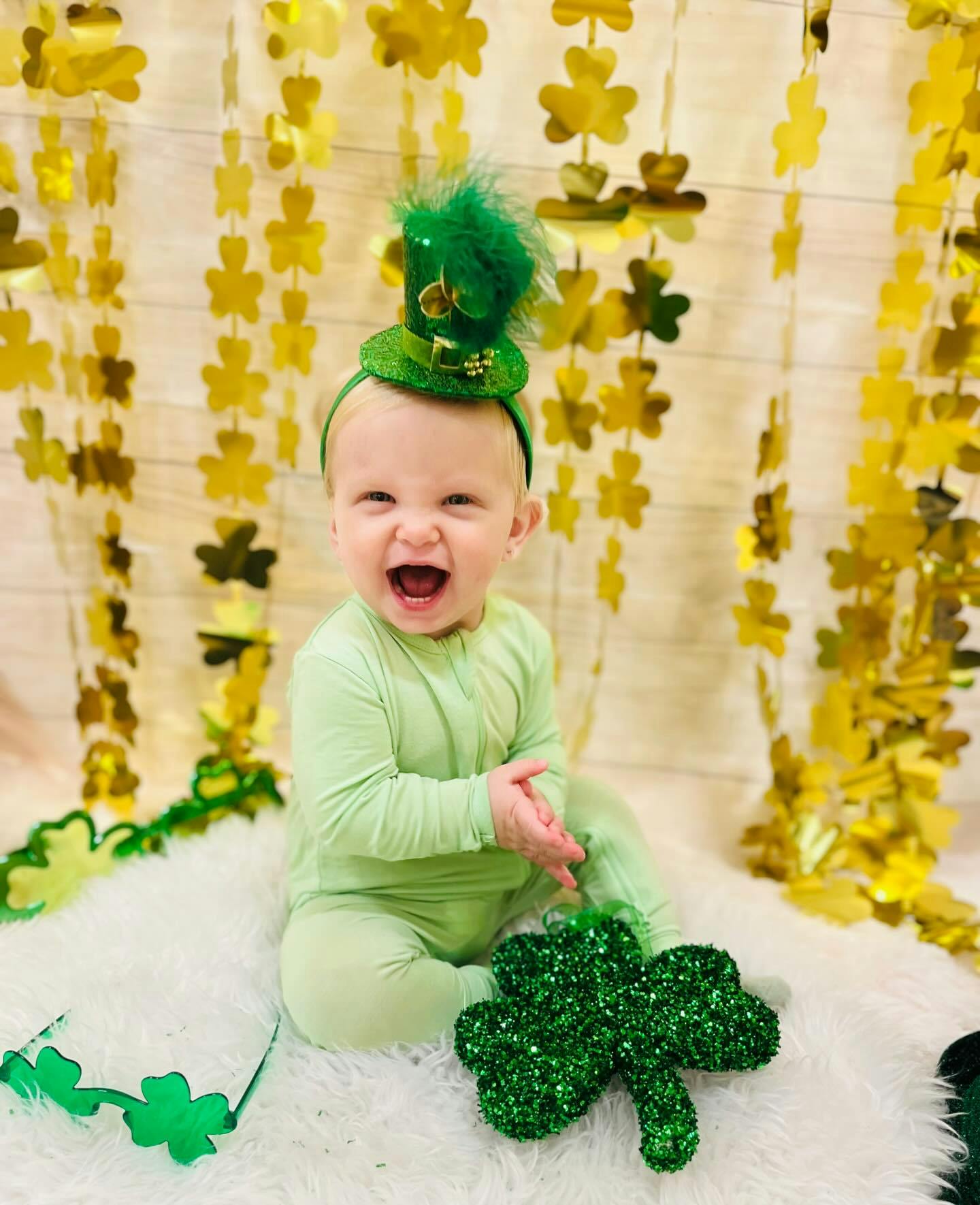 Child in green outfit and hat with a large green shamrock