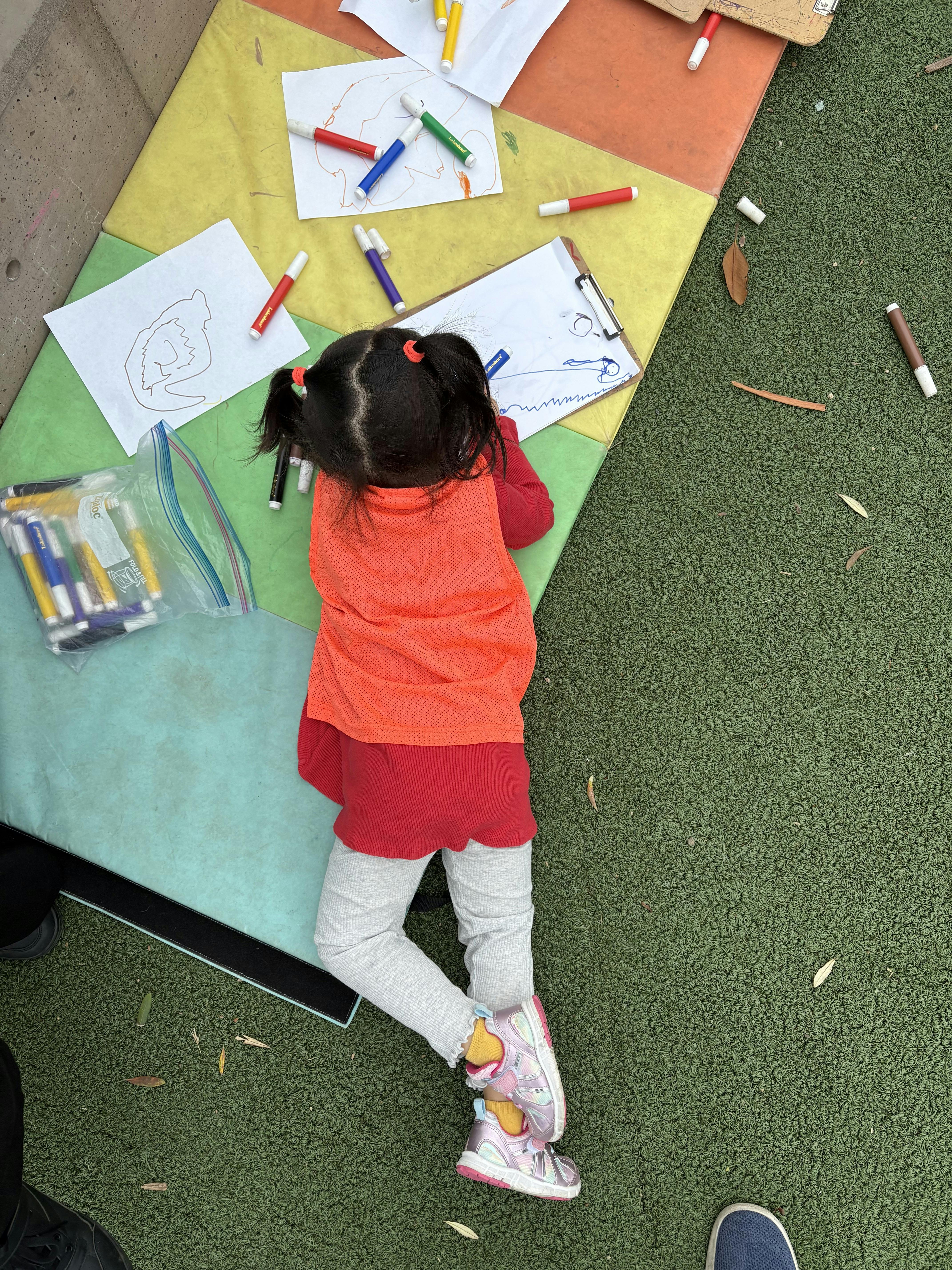 Child drawing on paper with markers