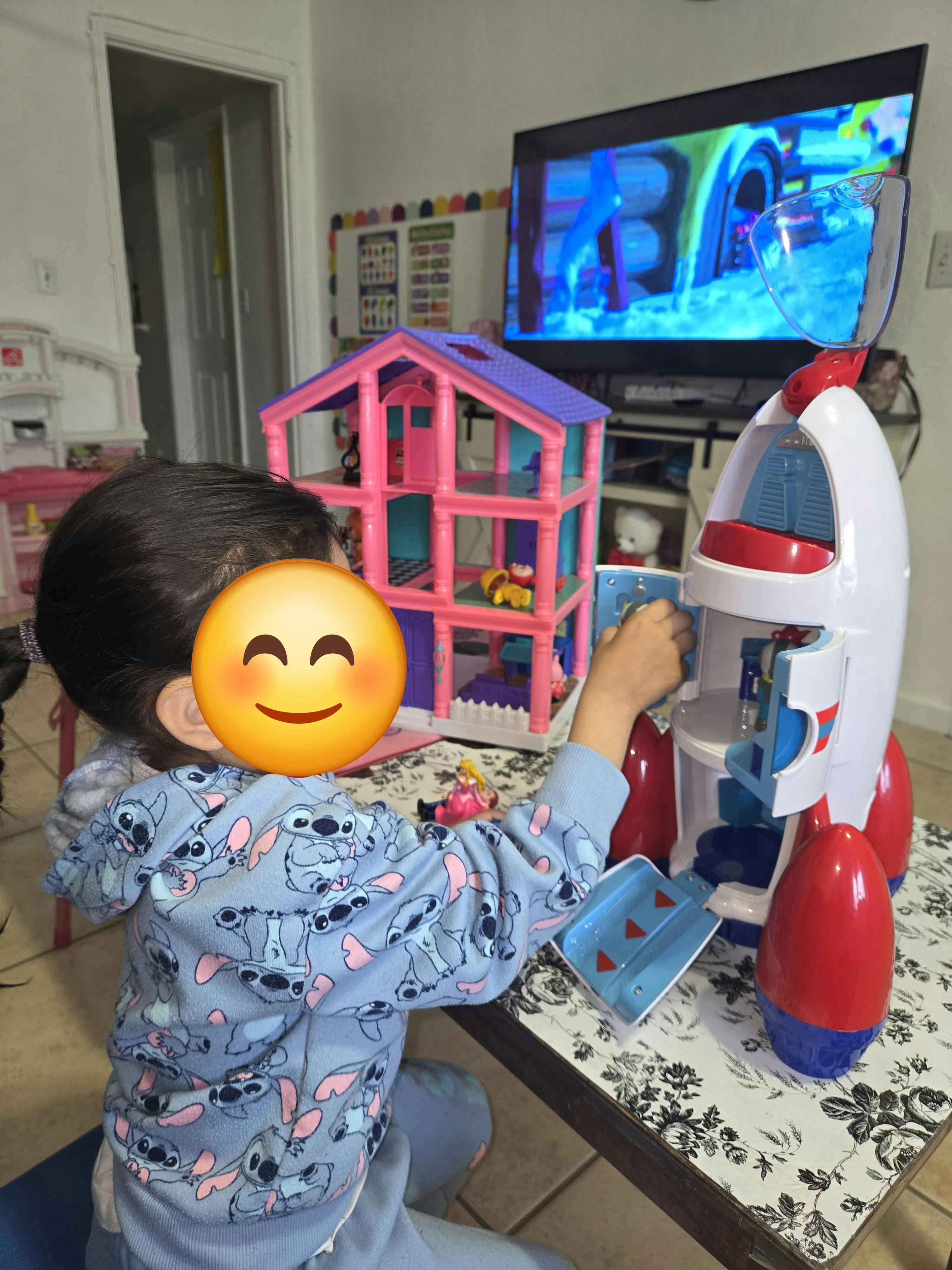 Child playing with a rocket toy on a table