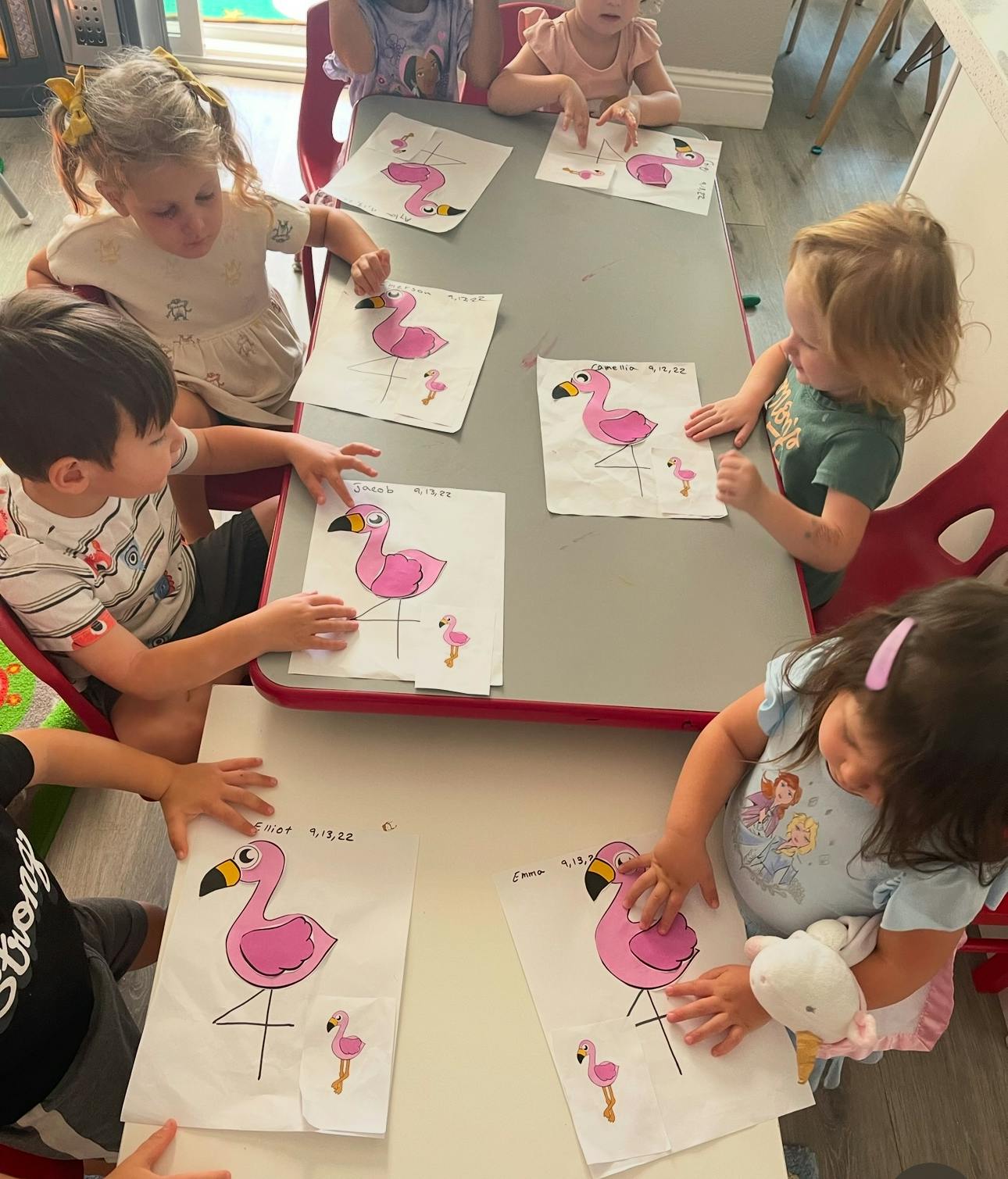 Children at a table working on flamingo craft projects