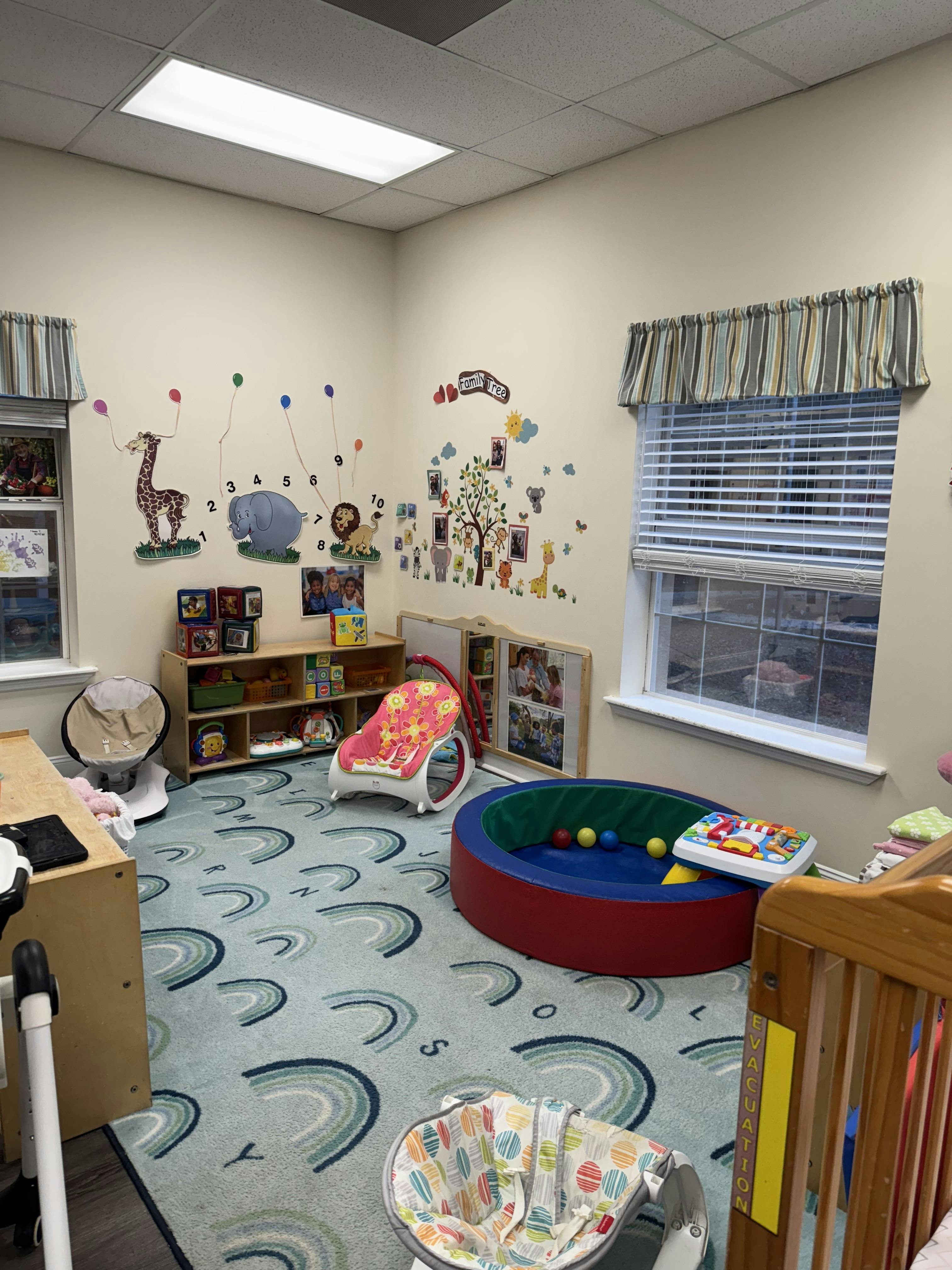 A brightly lit room with a colorful rug, toys, and wall decorations
