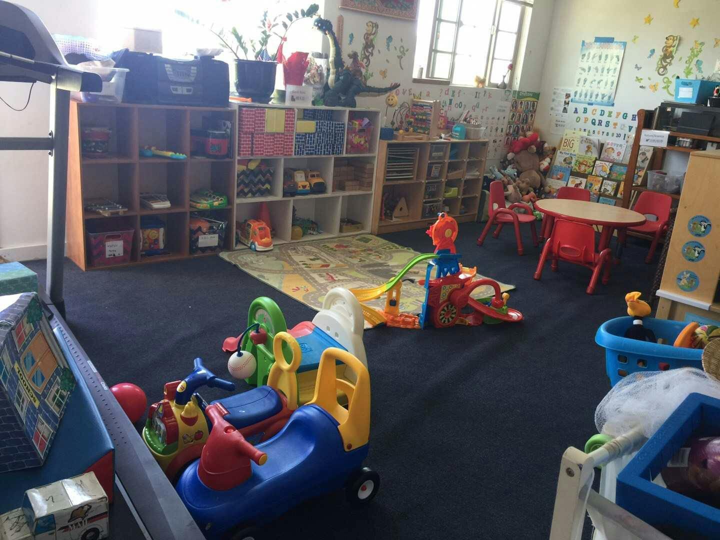 Playroom with toys, shelves, and small tables