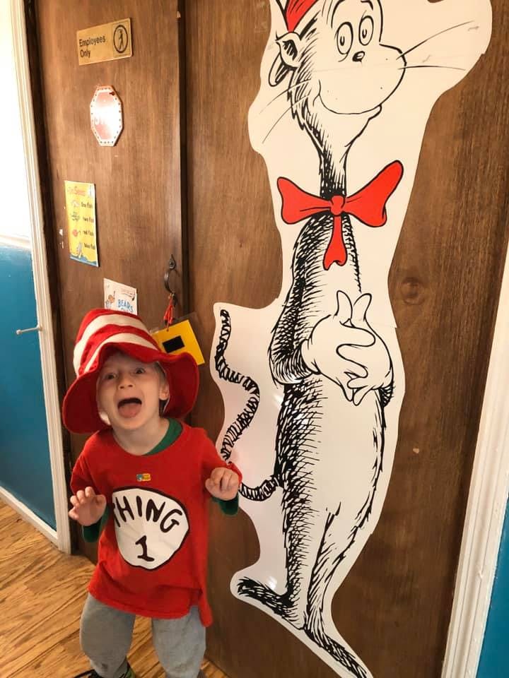 Child in a red and white striped hat and red shirt with "Thing 1" text