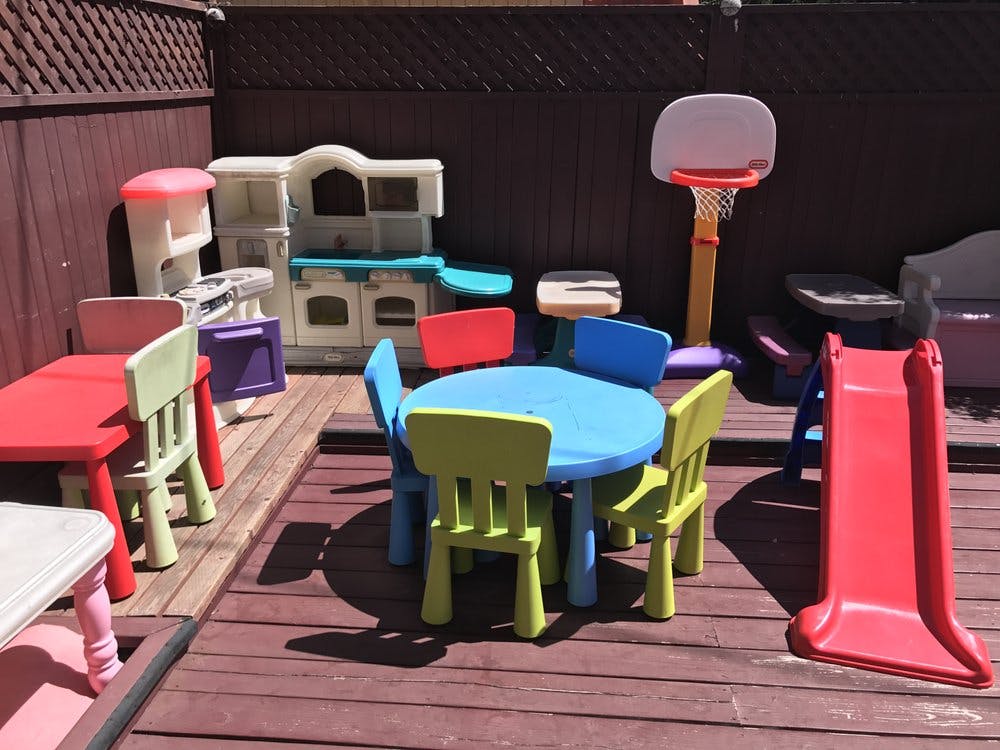 Children's play area with a table, chairs, slide, and play kitchen
