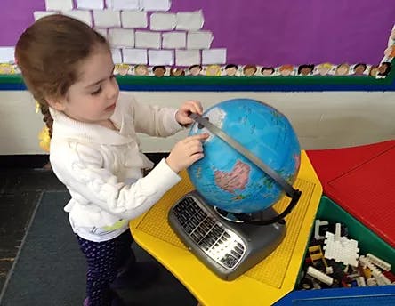 Child touching a globe