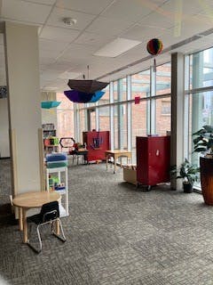 Empty classroom with small tables and red cabinets