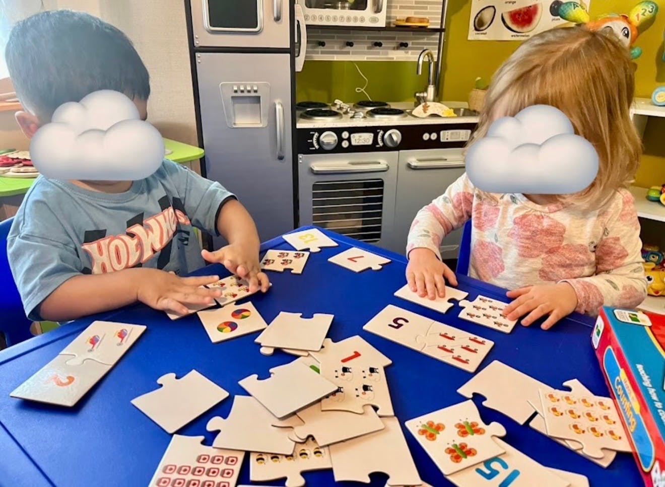 Two children playing with number and counting puzzles at a table