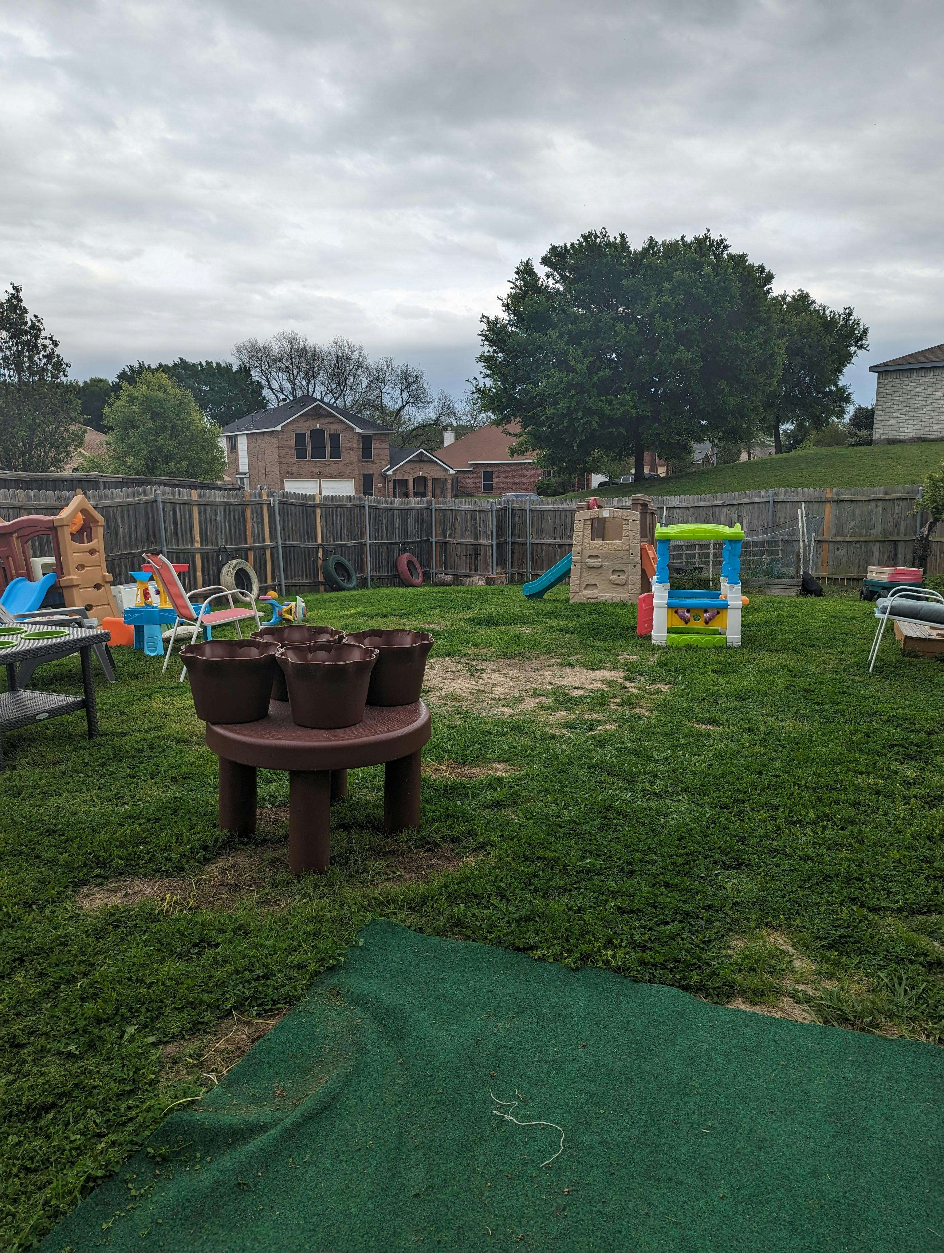 backyard with play equipment, grass, and a wooden fence