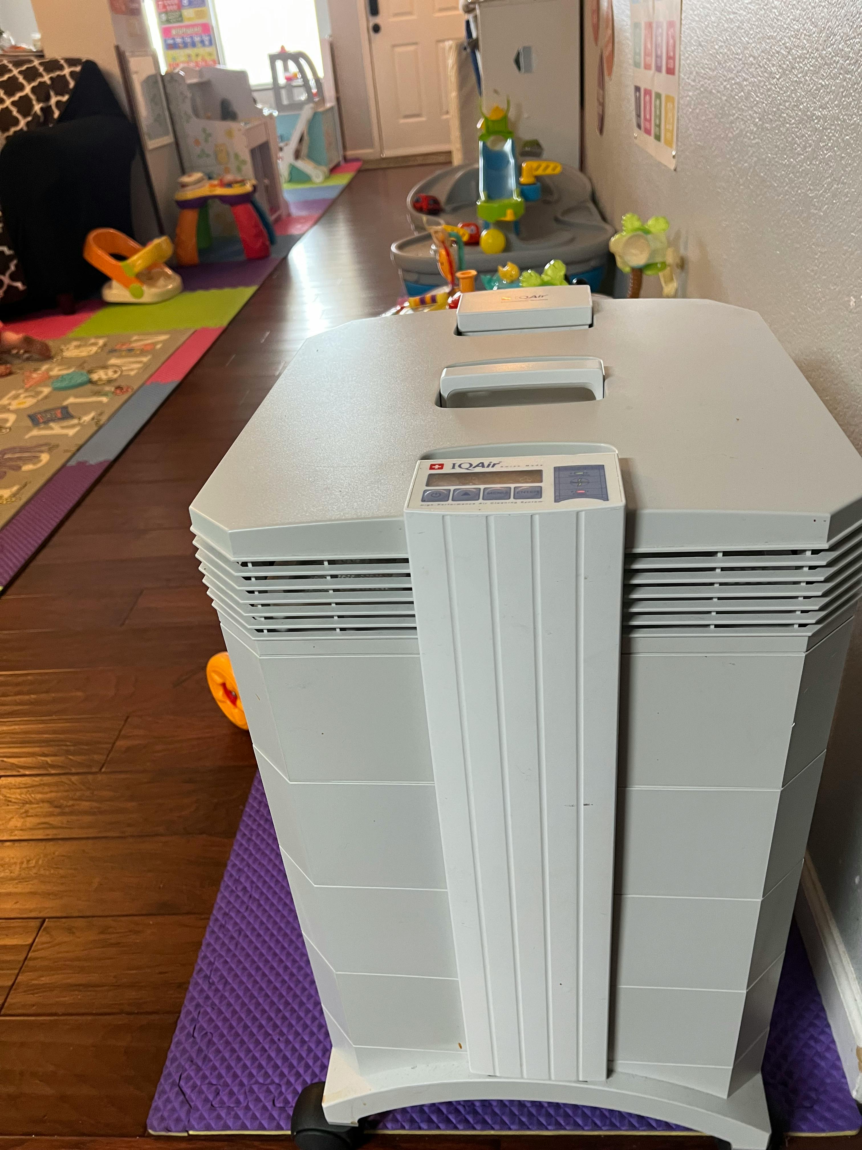 Air purifier in a room with toys and a colorful rug