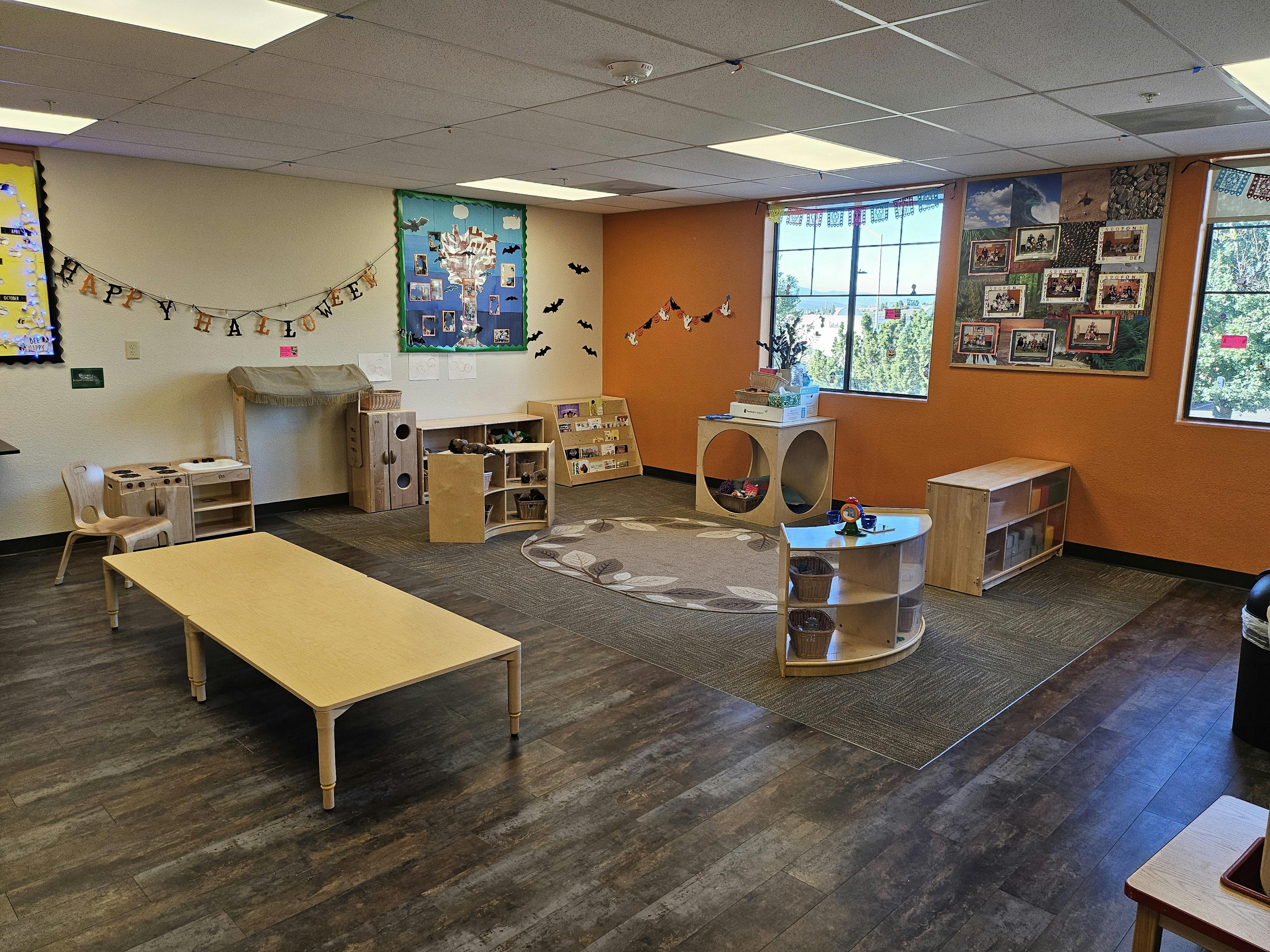 Empty classroom with tables, chairs, and learning materials