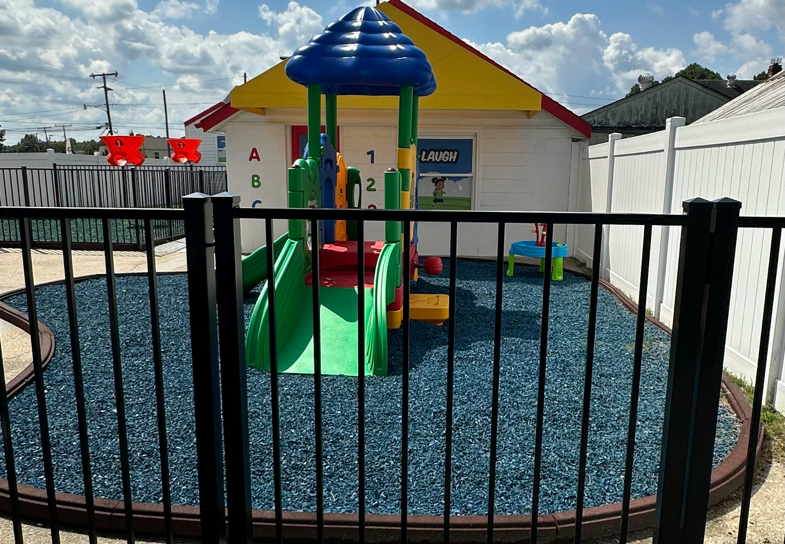 Playground with slide and climbing structure on blue ground cover