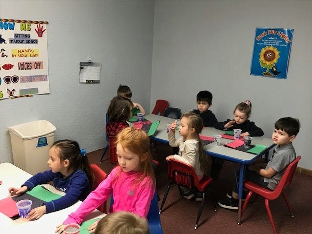Children sitting at tables in a classroom