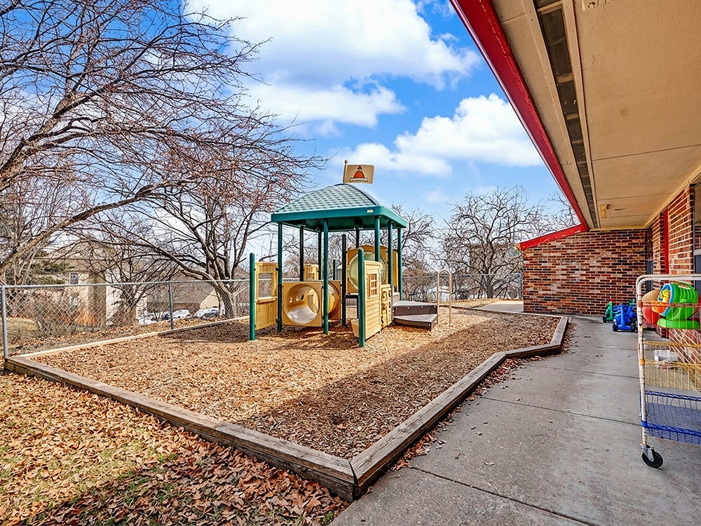 Outdoor playground with a multi-level structure and wood chip ground cover