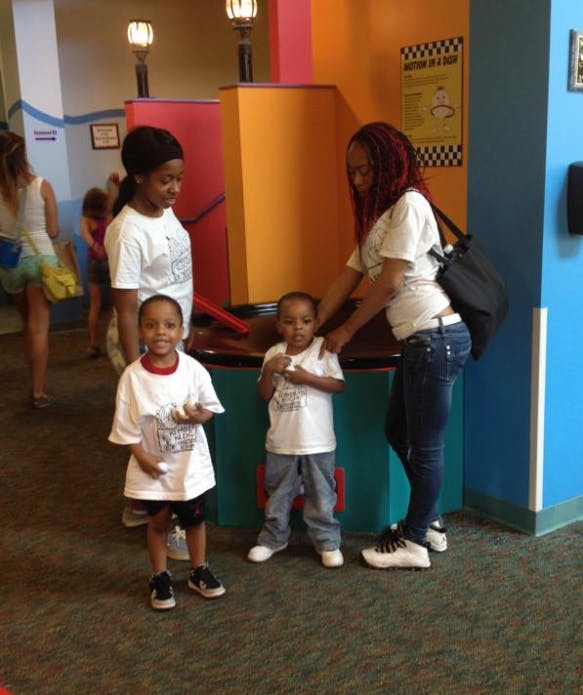 Two adults with two children standing indoors