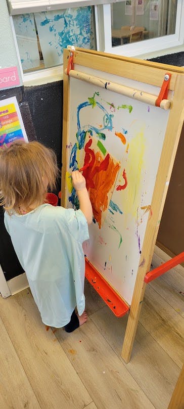 Child painting on an easel