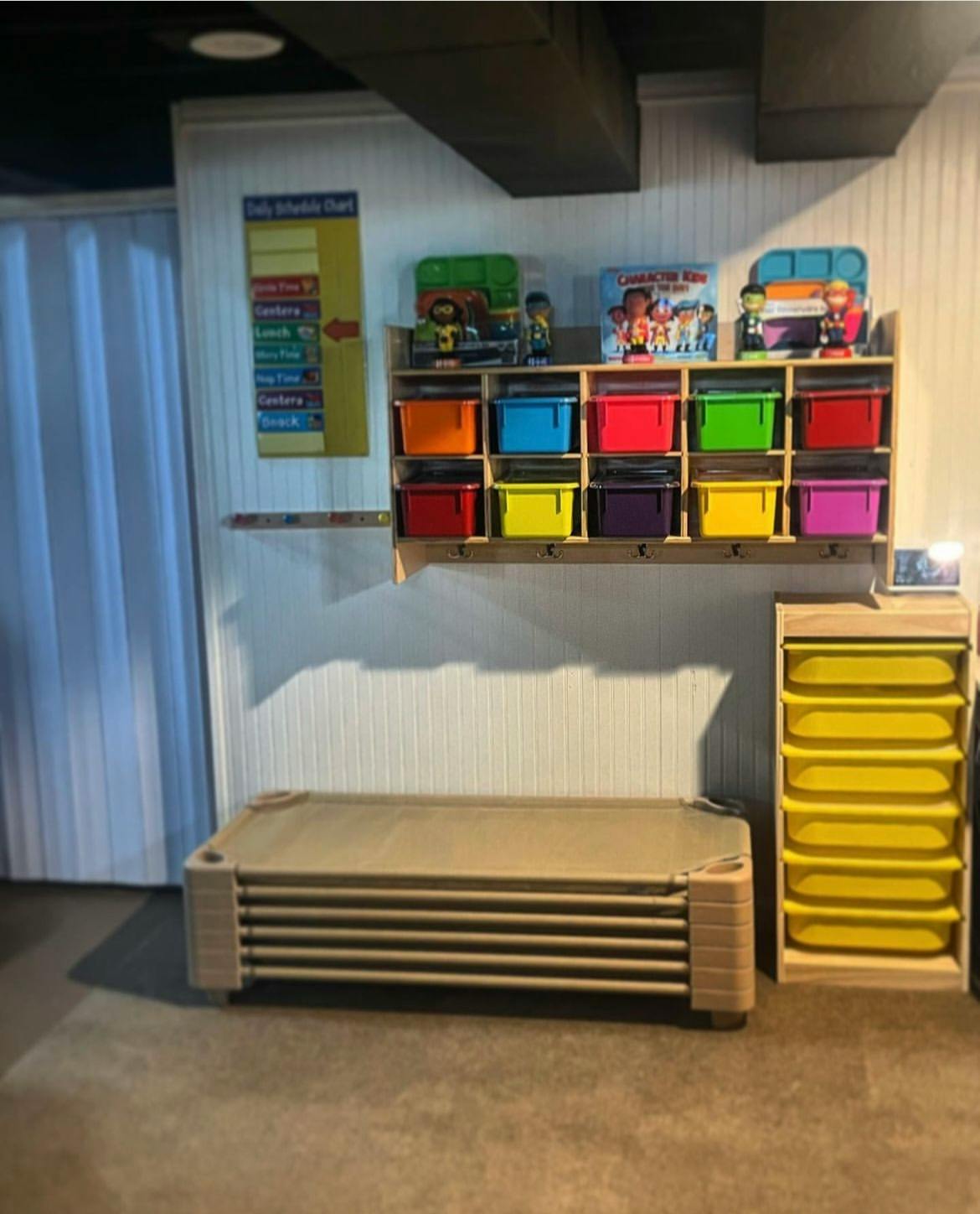 Stacked cots next to a storage unit with colorful bins