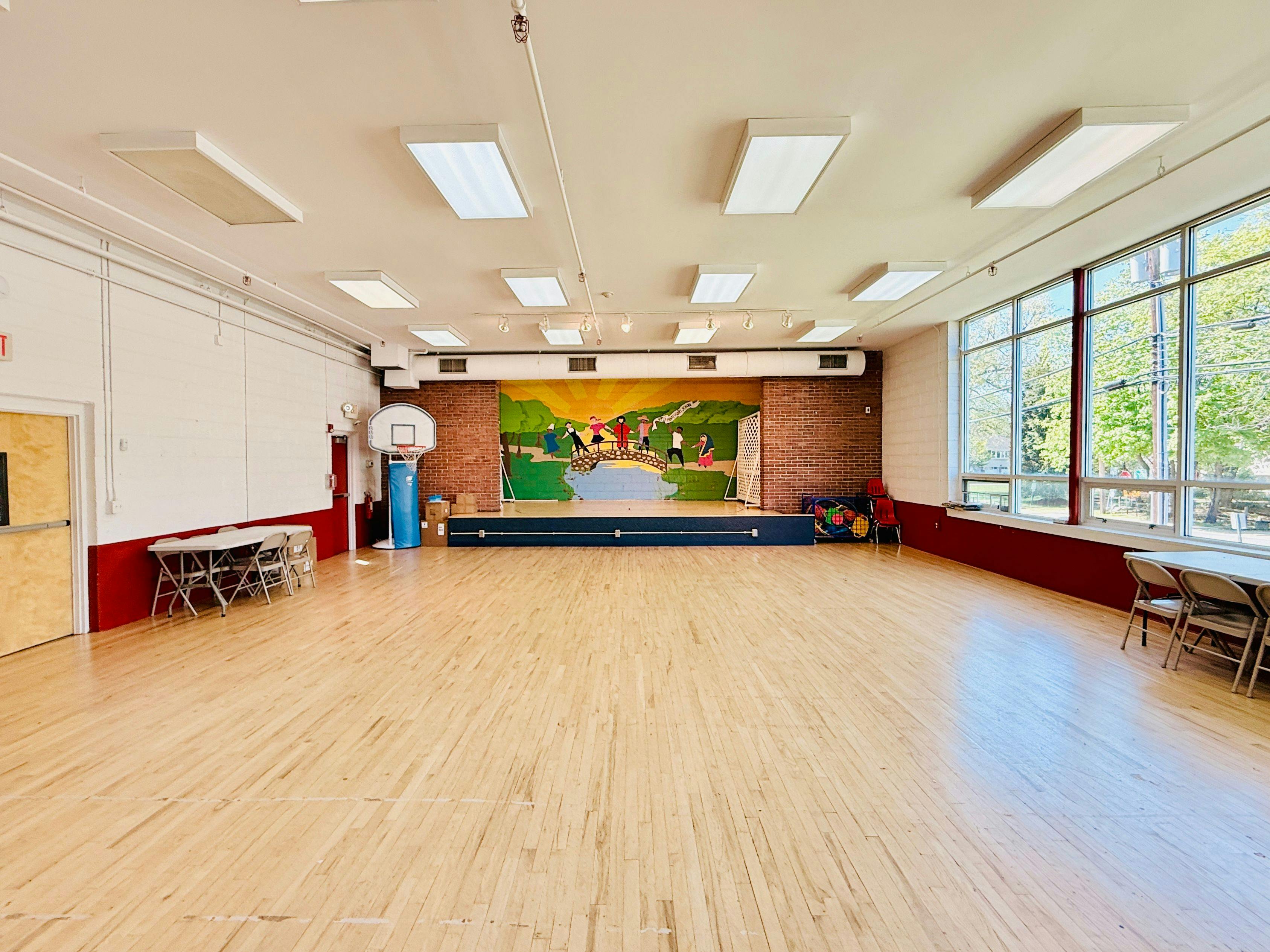 Empty auditorium or gymnasium with a mural on the stage background
