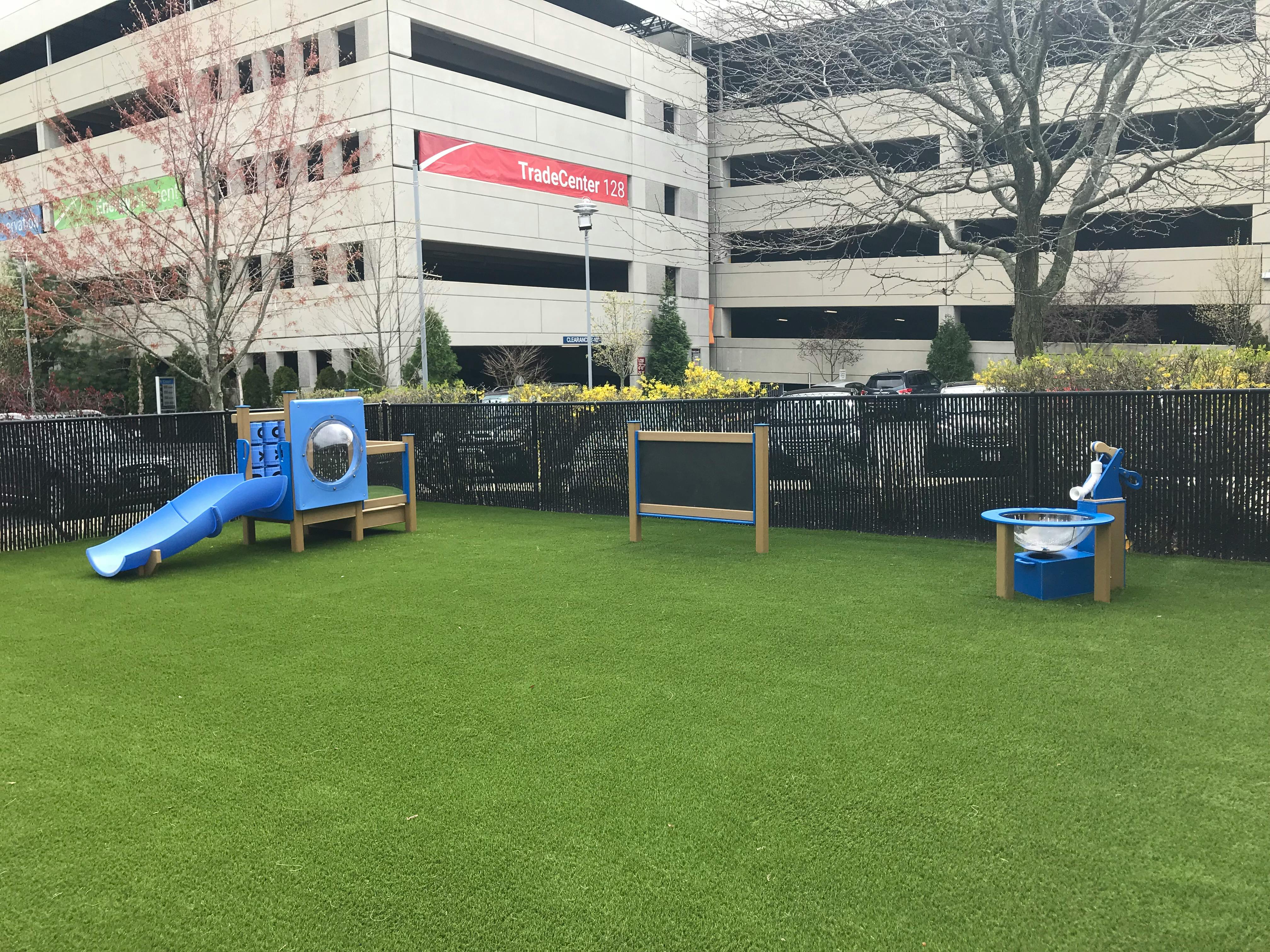 Playground with blue slide and sand table on green turf